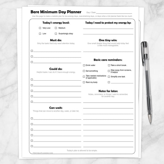Bare Minimum Day Planner Printable shown on a marble surface with a pen.