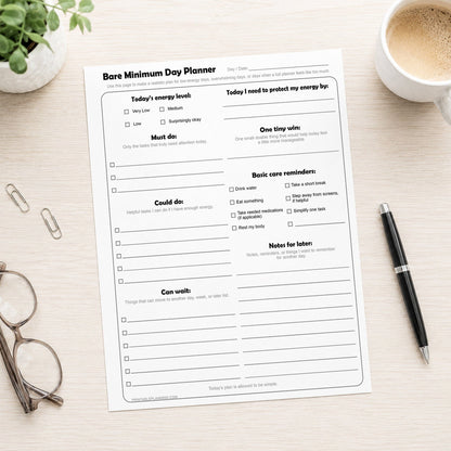 Bare Minimum Day Planner sheet on a desk with a cup of coffee, pen, and glasses.