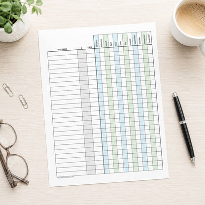 Blue Green Yearly Bill Payment Tracker with Amount Column (printable page) shown on a desk with glasses, a plant, paperclips, coffee, and a pen.