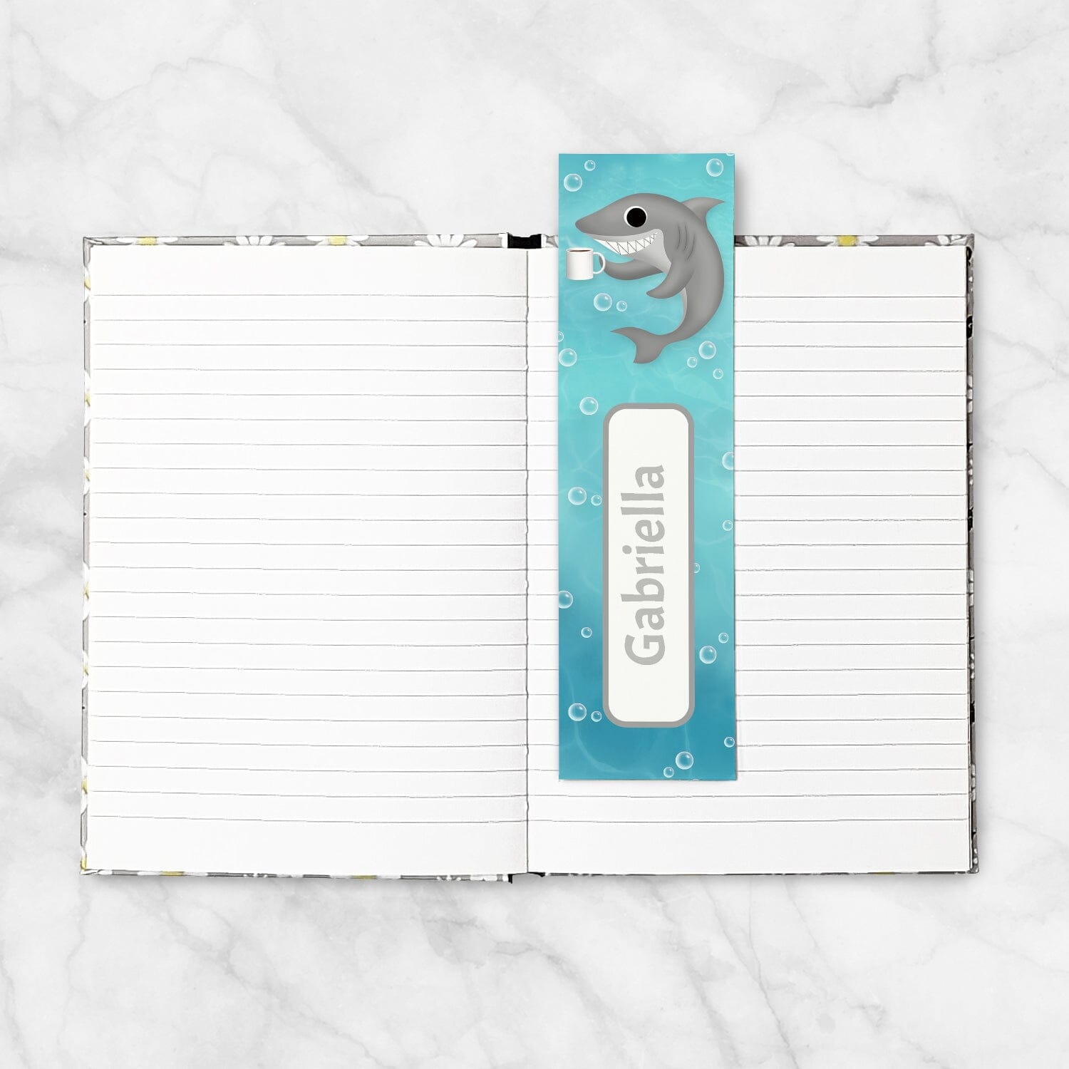 5x7 book shown with the 2x7 Personalized Coffee Shark Bookmark, on a marble surface.