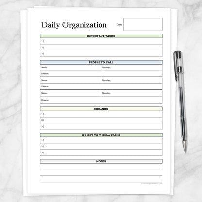 The printable Daily Planner with Priorities, Calls, Errands & Notes page shown on a marble surface with a pen.