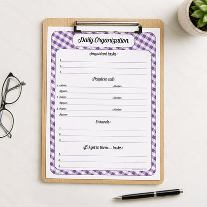 A printed purple gingham Daily Planner for Priorities, Calls, Errands & Tasks (printable) page shown on a wooden clipboard on a table with a plant, glasses, and a pen.