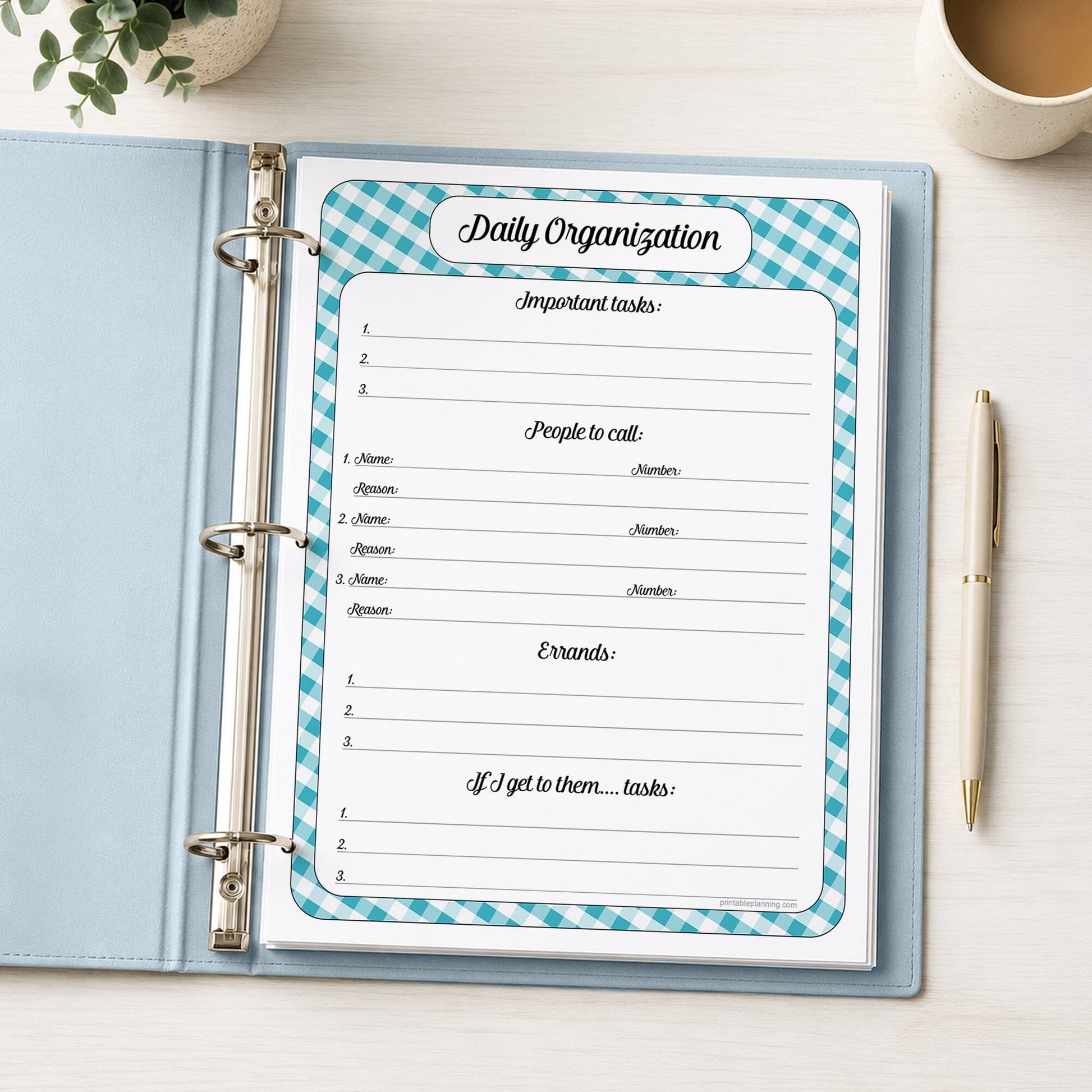 A printed turquoise gingham Daily Planner for Priorities, Calls, Errands & To-Dos (printable) page shown in a light blue binder on a desk with a plant, coffee, and a pen.
