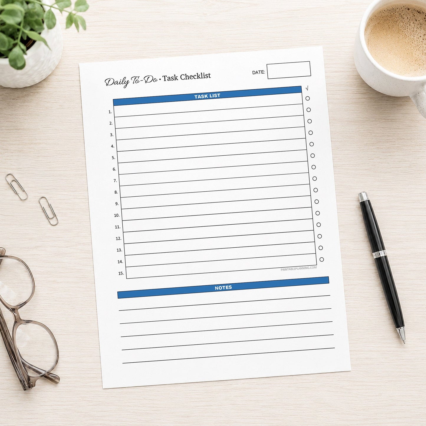 A printed Daily To-Do List & Task Checklist (printable) page, in blue, shown on a desk with a plant, paperclips, glasses, coffee, and a pen.