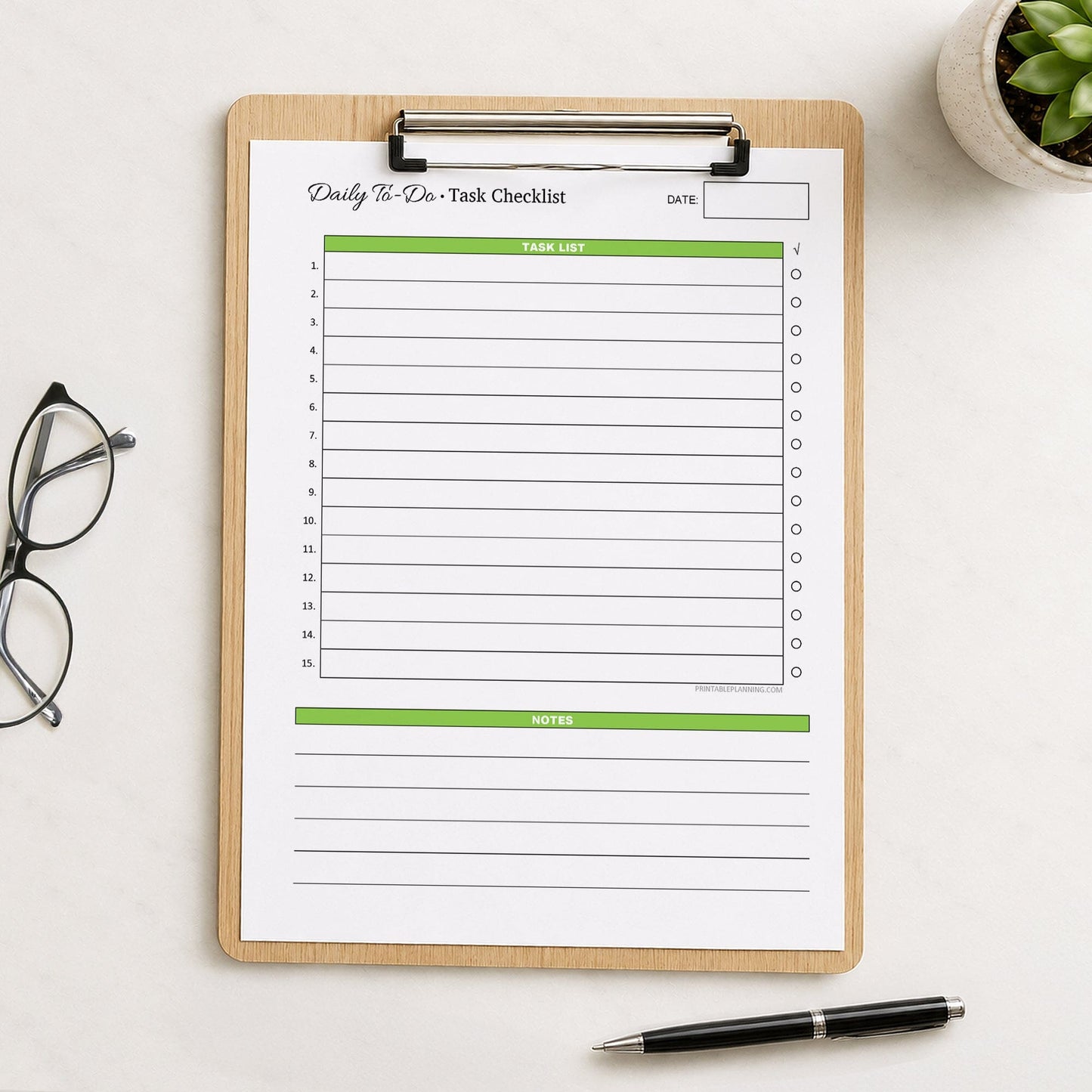 A printed Daily To-Do List & Task Checklist (printable) page, in green, shown on a wooden clipboard on a table with a plant, glasses, and a pen.