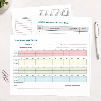Three printed pages of the printable Debt Snowball, Debt Payoff Plan & Yearly Bill Tracker Bundle shown on a desk with a plant, paperclips, and a pen.