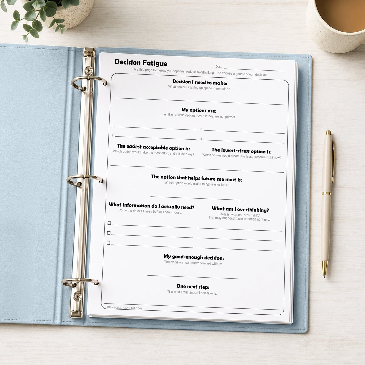 Decision Fatigue Printable Worksheet in a blue binder on a desk with a coffee, pen, and plant.