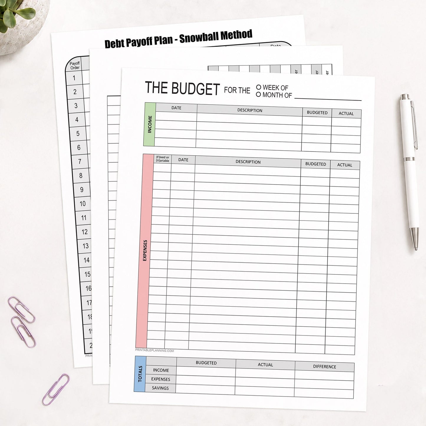 Three printed pages of the Financial Planning Bundle with Budget, Bill Tracker & Debt Payoff (printable pages) shown on a desk with a plant, paperclips, and a pen.