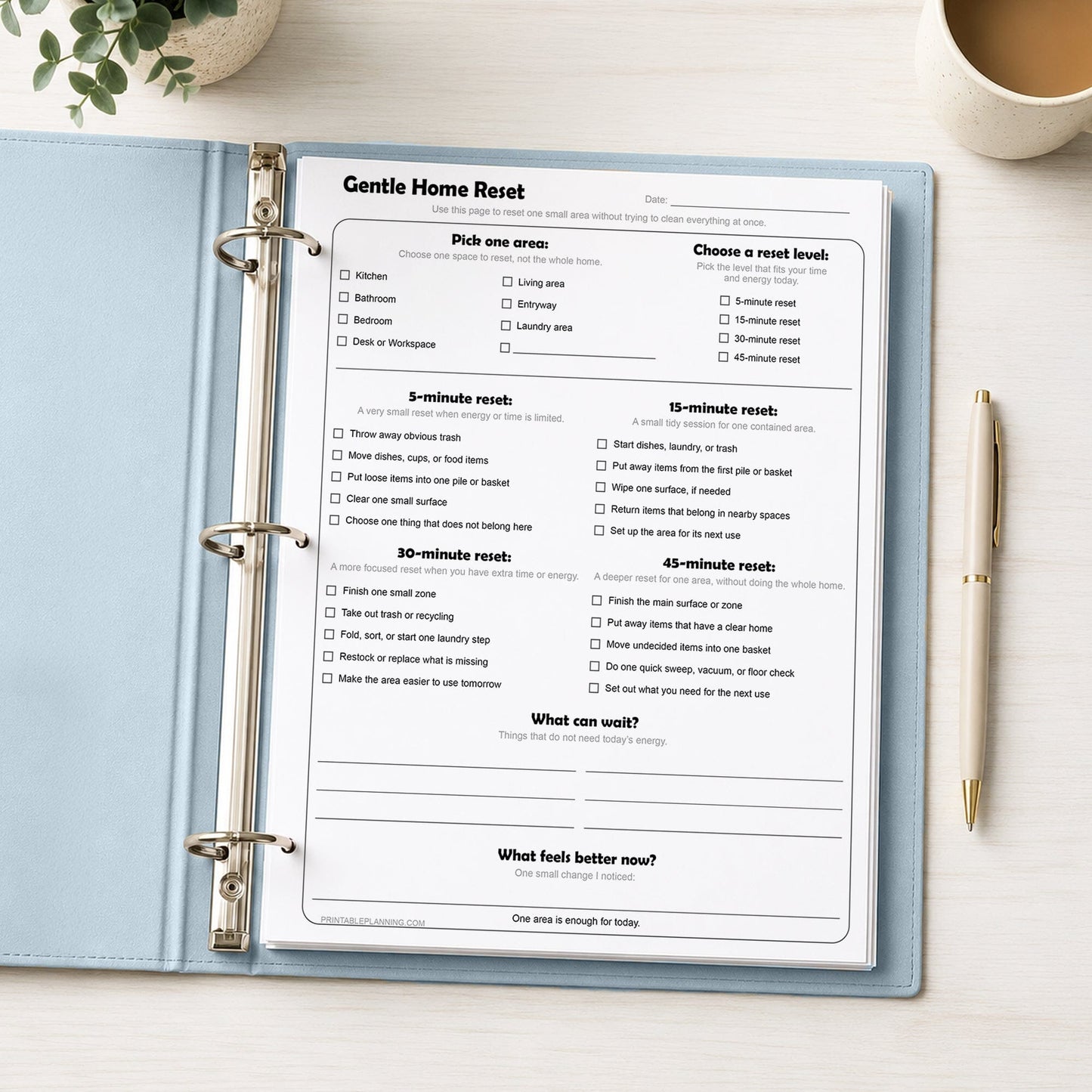 Gentle Home Reset Printable Checklist shown in a light blue binder on a desk with a plant, coffee, and a pen.
