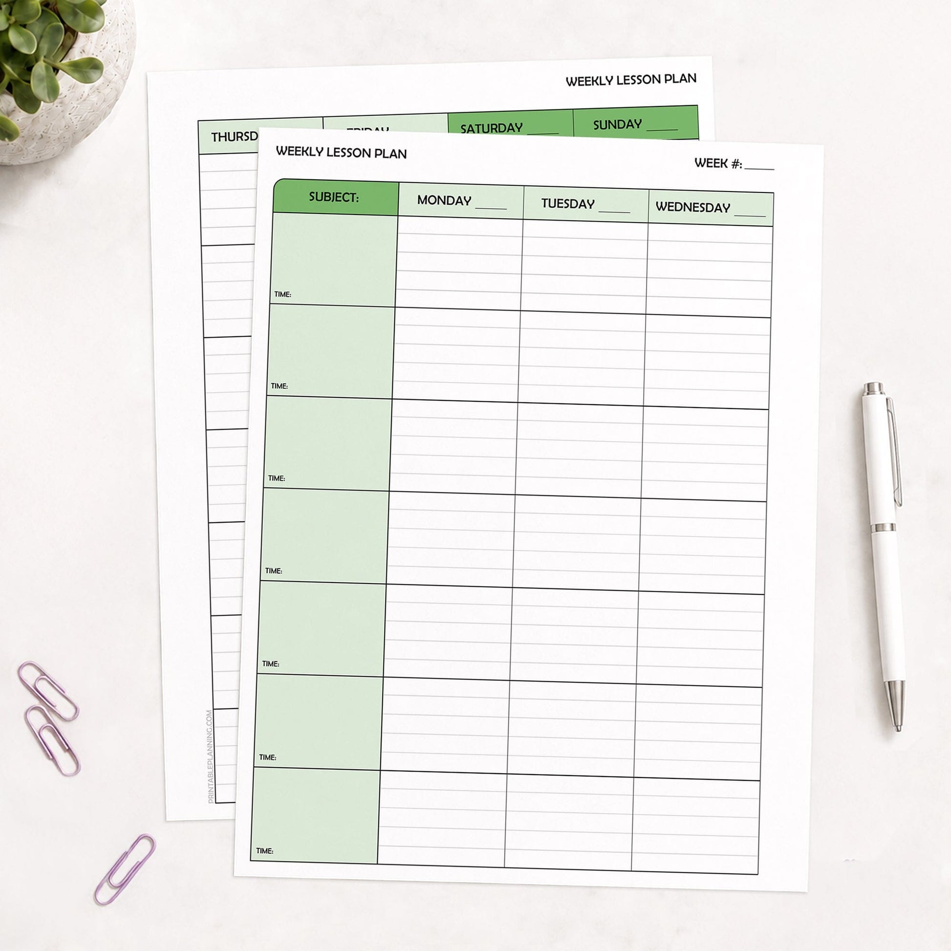 Two front and back printed Green Weekly Lesson Plan Pages for Teachers (printable) pages shown on a table with a plant, paperclips, and a pen.