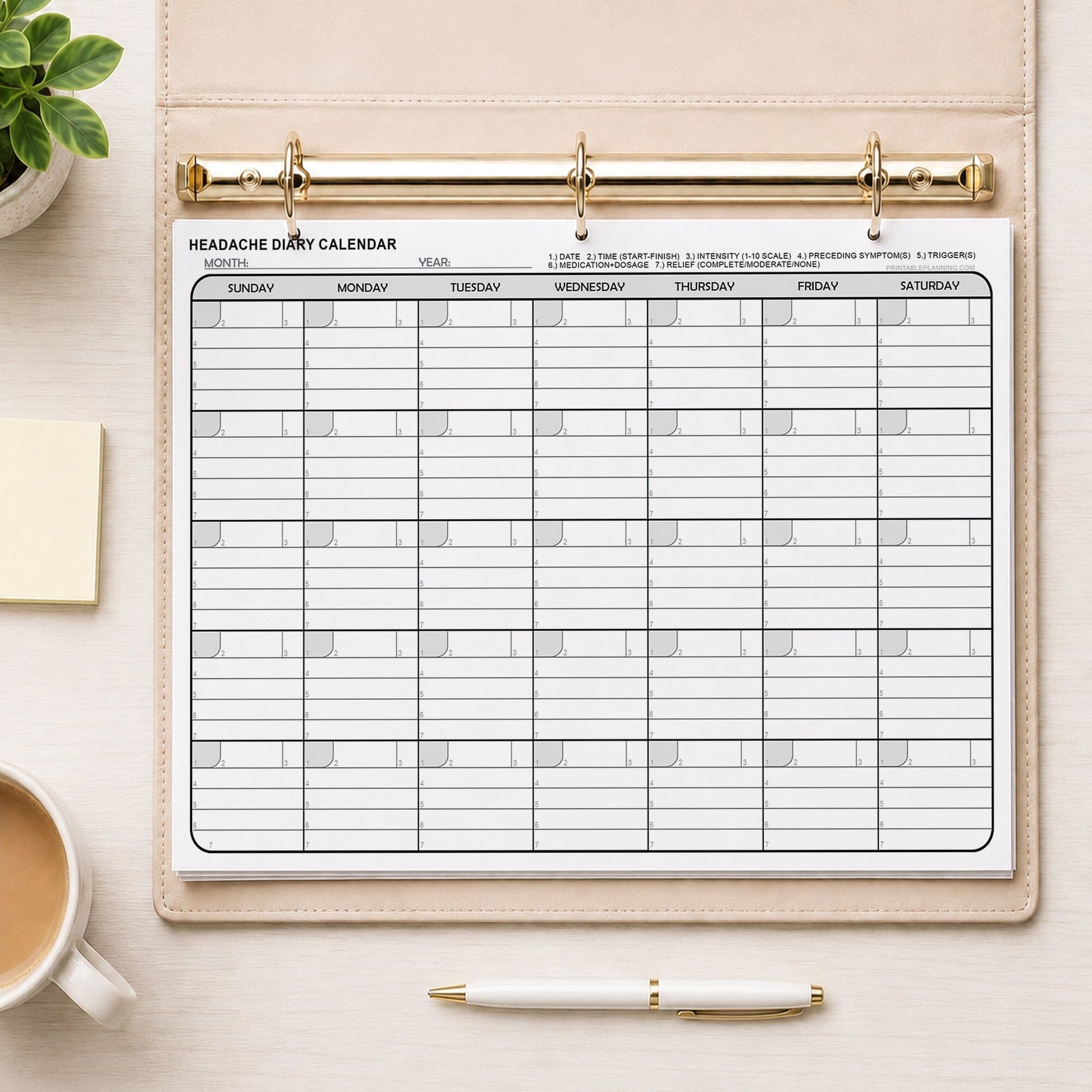 Printable Headache Diary Calendar - Monthly Migraine Tracker PDF in a beige binder on a desk with a plant, notes, coffee, and a pen.