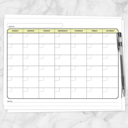 The printable Undated Monthly Calendar - Yellow Full-Page Planner page shown on a marble surface with a pen.