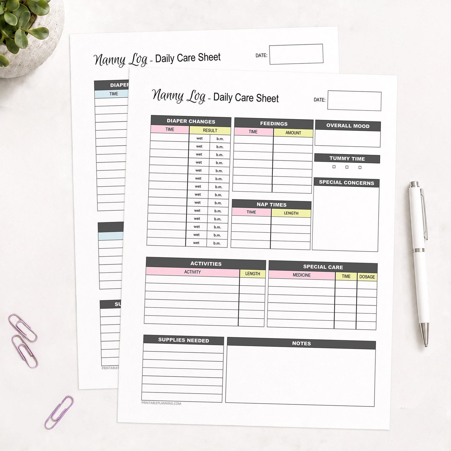 Two printed Nanny Log Daily Infant Care Sheets - 2 Printable Color Versions, pink/yellow and blue/green, shown on a table with a plant, paperclips, and a pen.