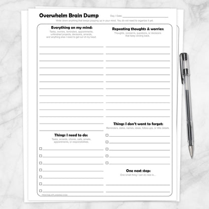Printable Overwhelm Brain Dump Worksheets shown with a pen on a marble surface.