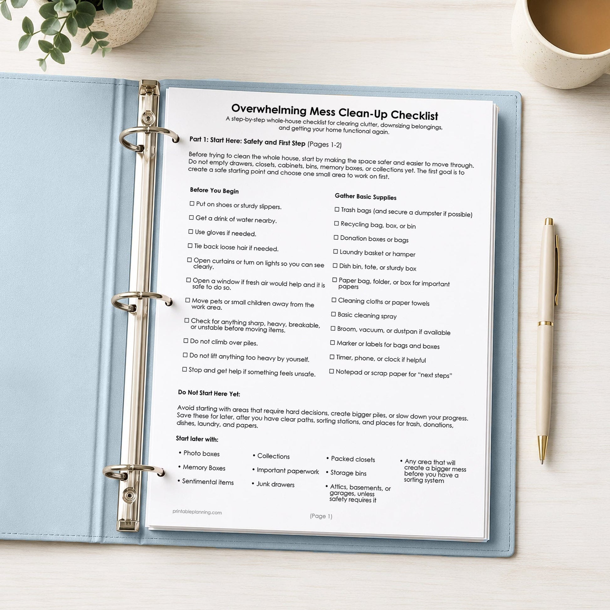 Printed first page of the printable Overwhelming Mess Clean-Up Checklist shown in a light blue binder on a desk with a plant, coffee, and a pen.