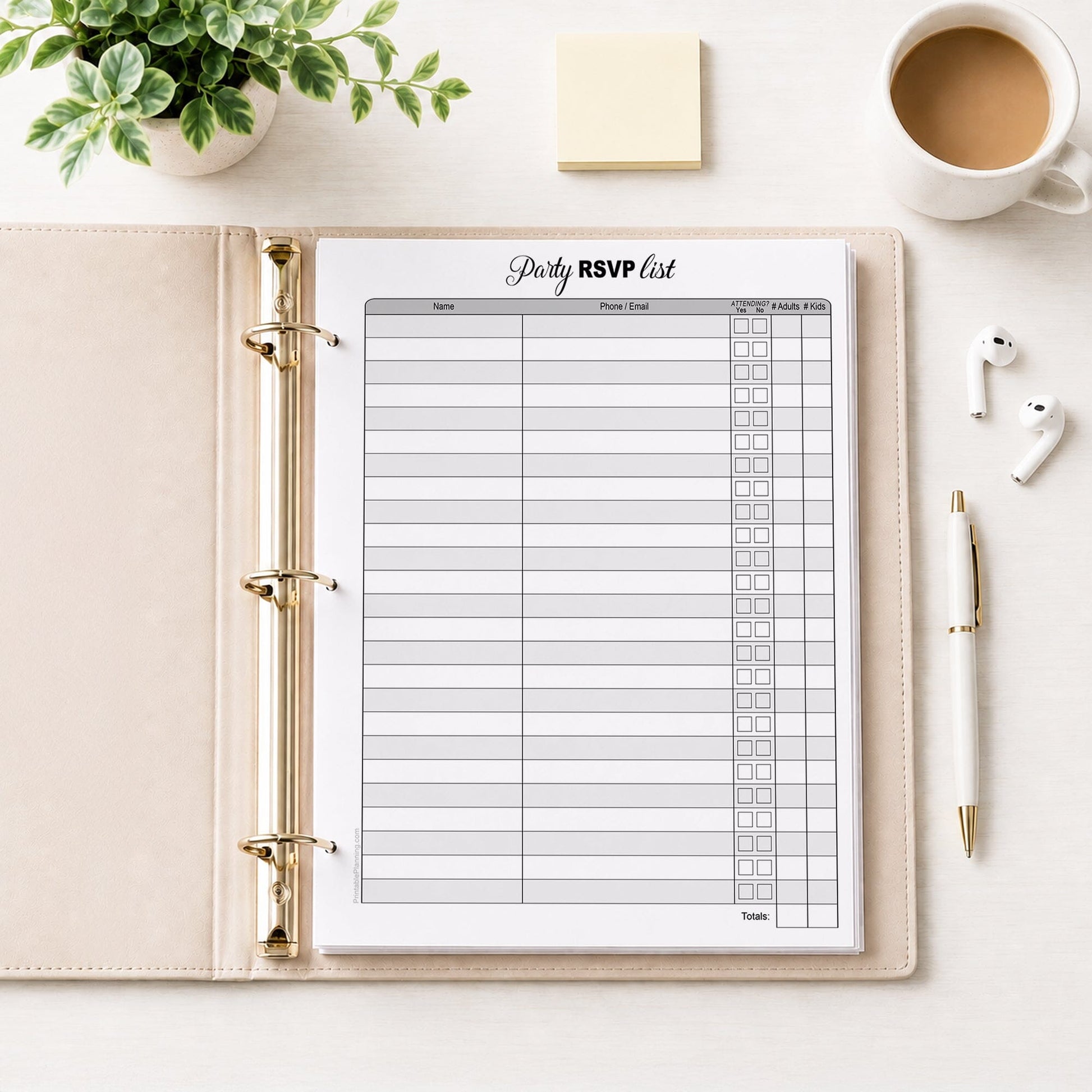 Printable Party RSVP List shown in a beige binder on a desk with earbuds, notes, coffee, a plant, and a pen.
