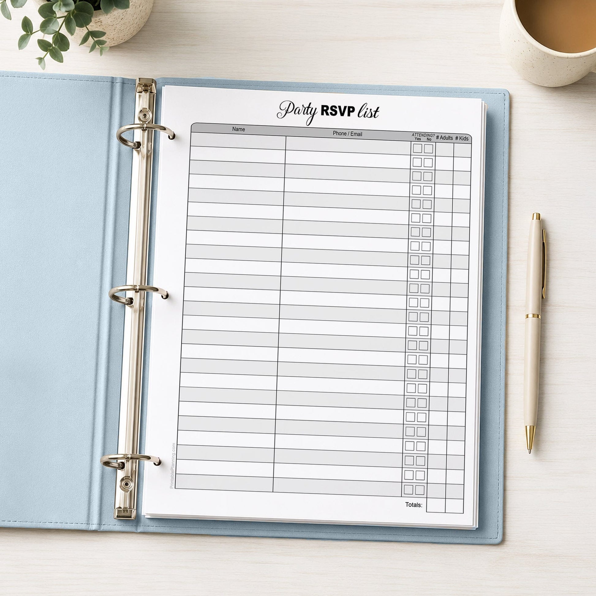 Printable Party RSVP List shown in a light blue binder on a desk with a plant, coffee, and a pen.