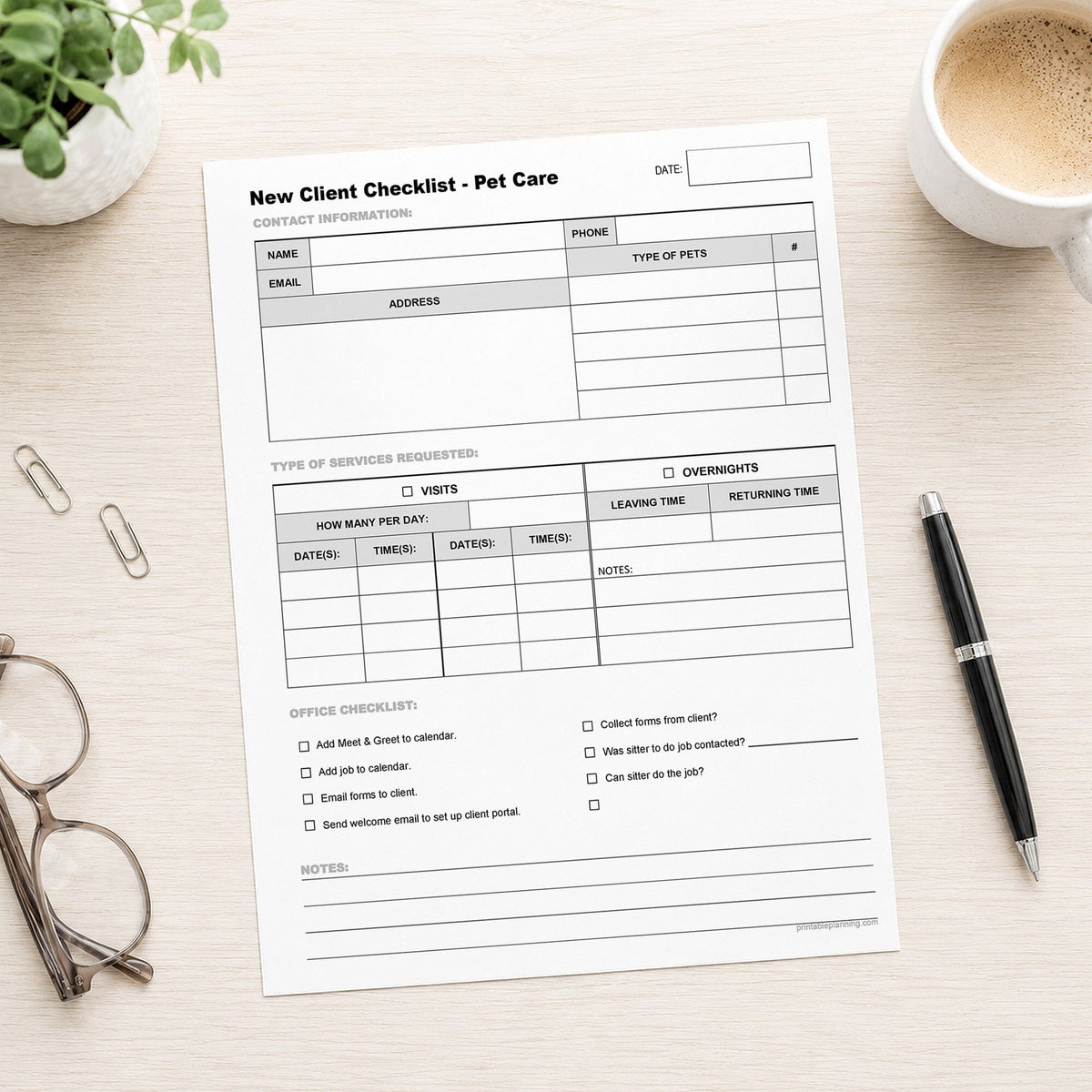 A printed Pet Sitter New Client Checklist for Visits and Overnights (printable page) shown on a desk with a plant, glasses, paperclips, coffee, and a pen.