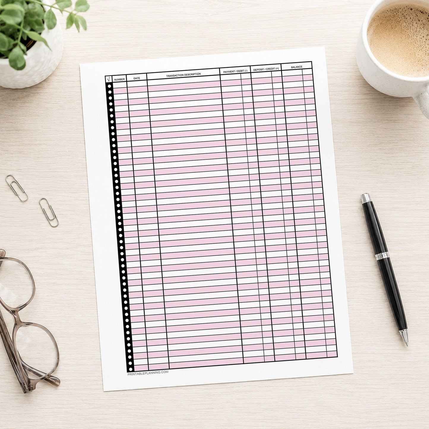 Pink Printable Check Register - Full-Page Transaction Tracker shown on a desk with glasses, coffee, plant, and a pen.