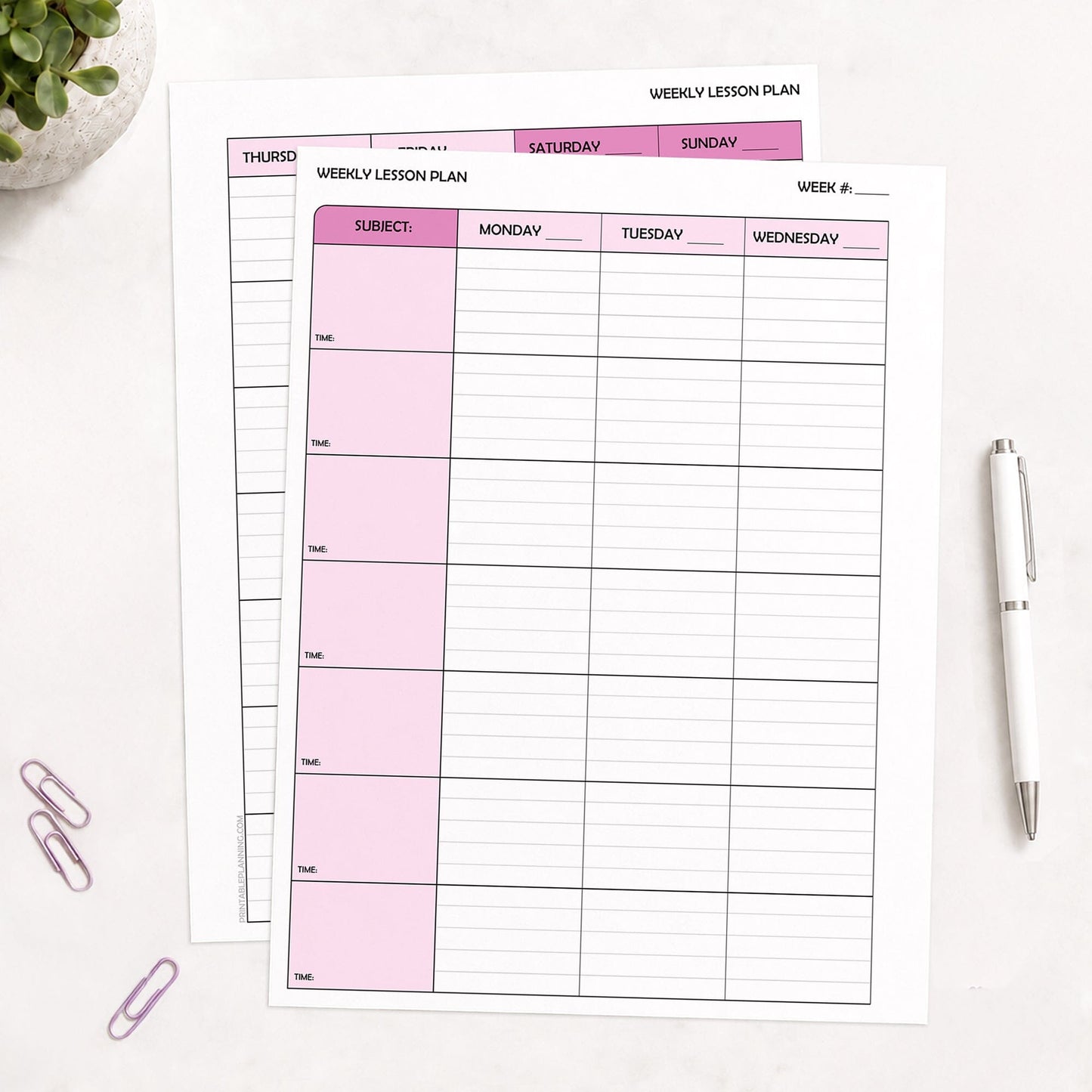 Two front and back printed Pink Weekly Lesson Plan Pages for Teachers (printable) pages shown on a table with a plant, paperclips, and a pen.