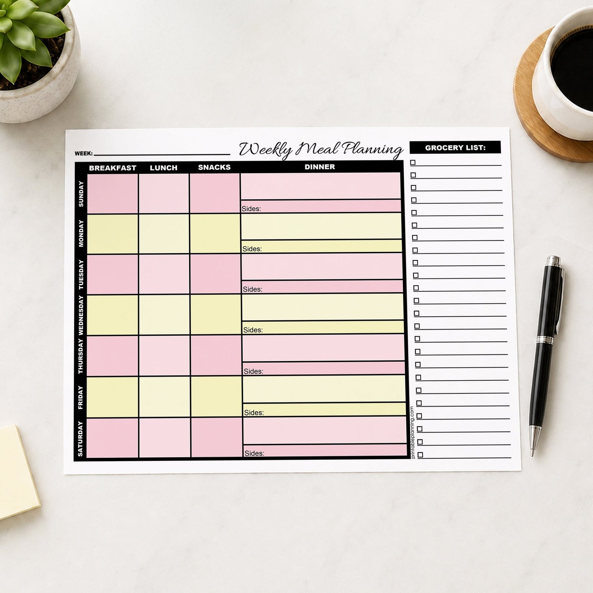 A printed Pink Yellow Weekly Meal Planner with Grocery List (printable) page displayed on a light table surface, surrounded by lifestyle props including a potted succulent, a cup of coffee, and a black pen.