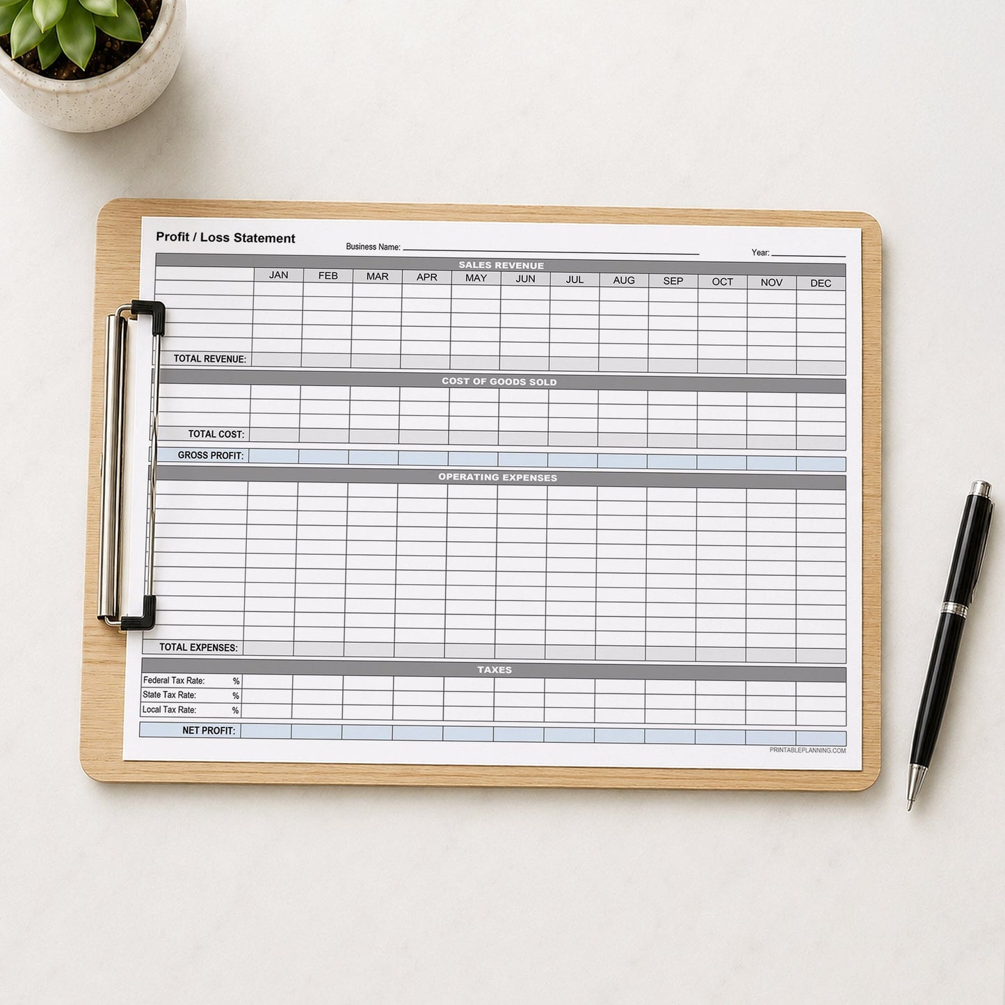 A printed Annual Profit and Loss Statement for Small Business (printable page) shown on a wooden clipboard on a table with a plant and a pen.