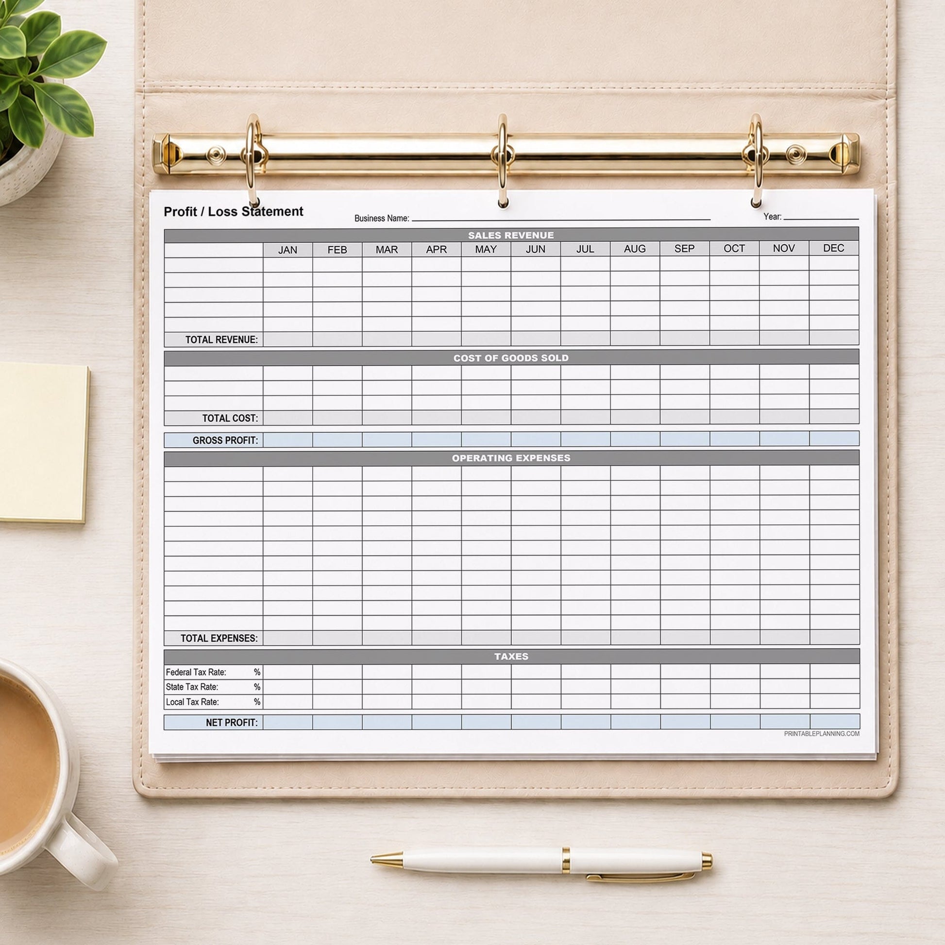 A printed Annual Profit and Loss Statement for Small Business (printable page) shown in a beige binder on a desk with a plant, sticky notes, coffee, and a pen.