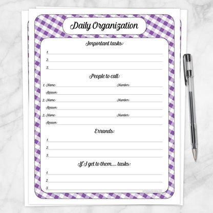 The printable Purple Gingham Daily Planner for Priorities, Calls, Errands & Tasks page shown on a marble surface with a pen.
