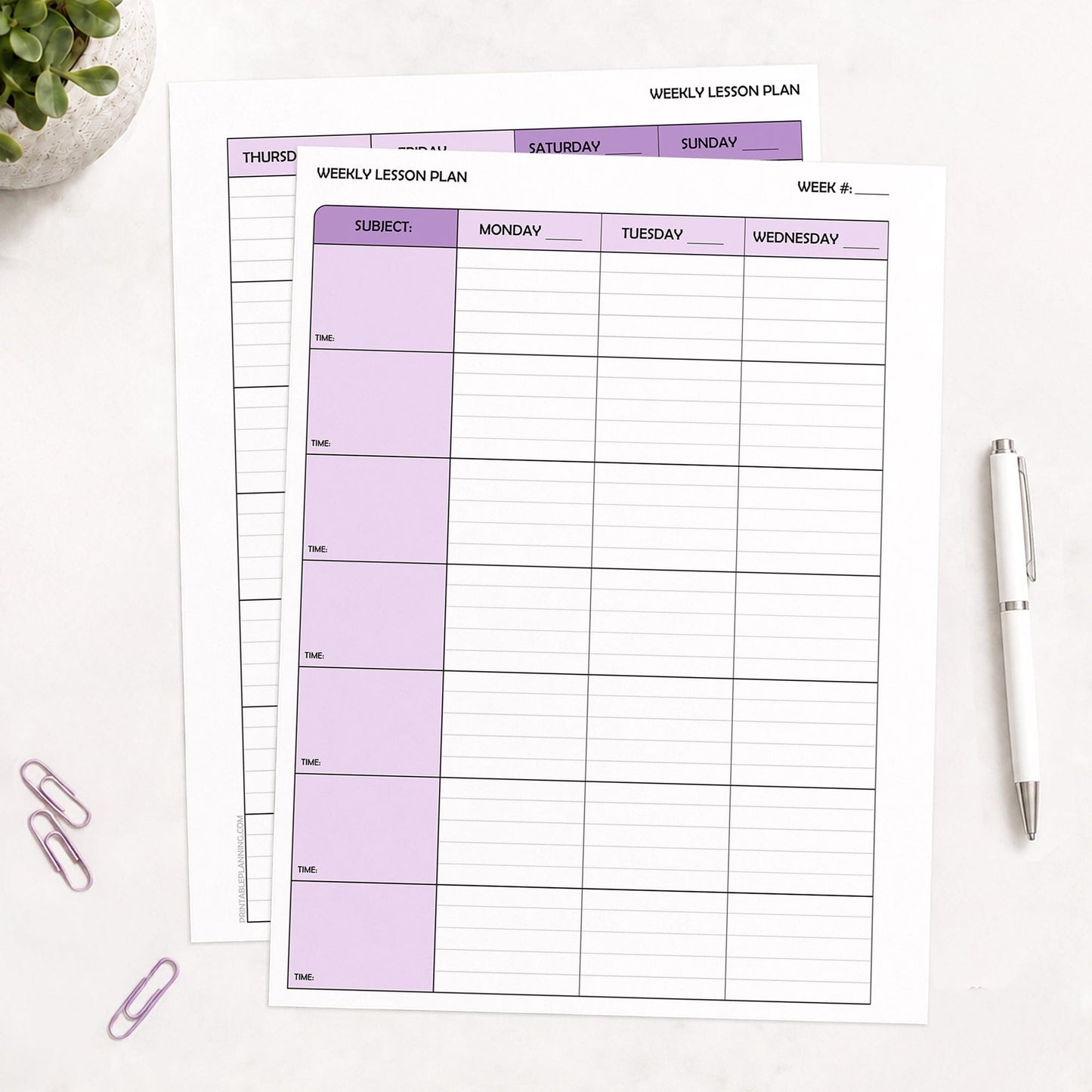 Two front and back printed Purple Weekly Lesson Plan Pages for Teachers shown on a table with a plant, paperclips, and a pen.