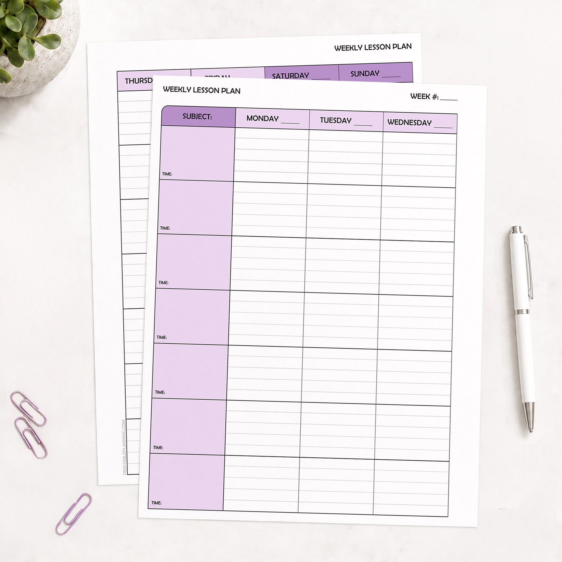 Two front and back printed Purple Weekly Lesson Plan Pages for Teachers shown on a table with a plant, paperclips, and a pen.