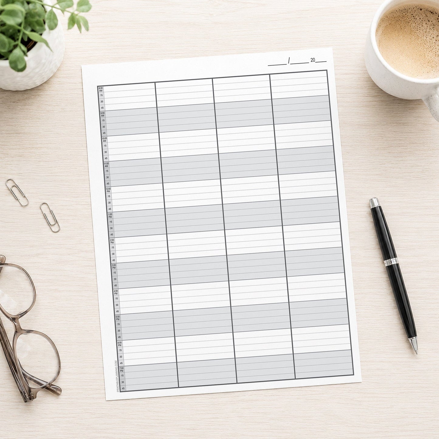 Schedule Sheet in 15 Minute Increments, 4 Columns (printable page) shown on a desk with glasses, coffee, a plant, and a pen.