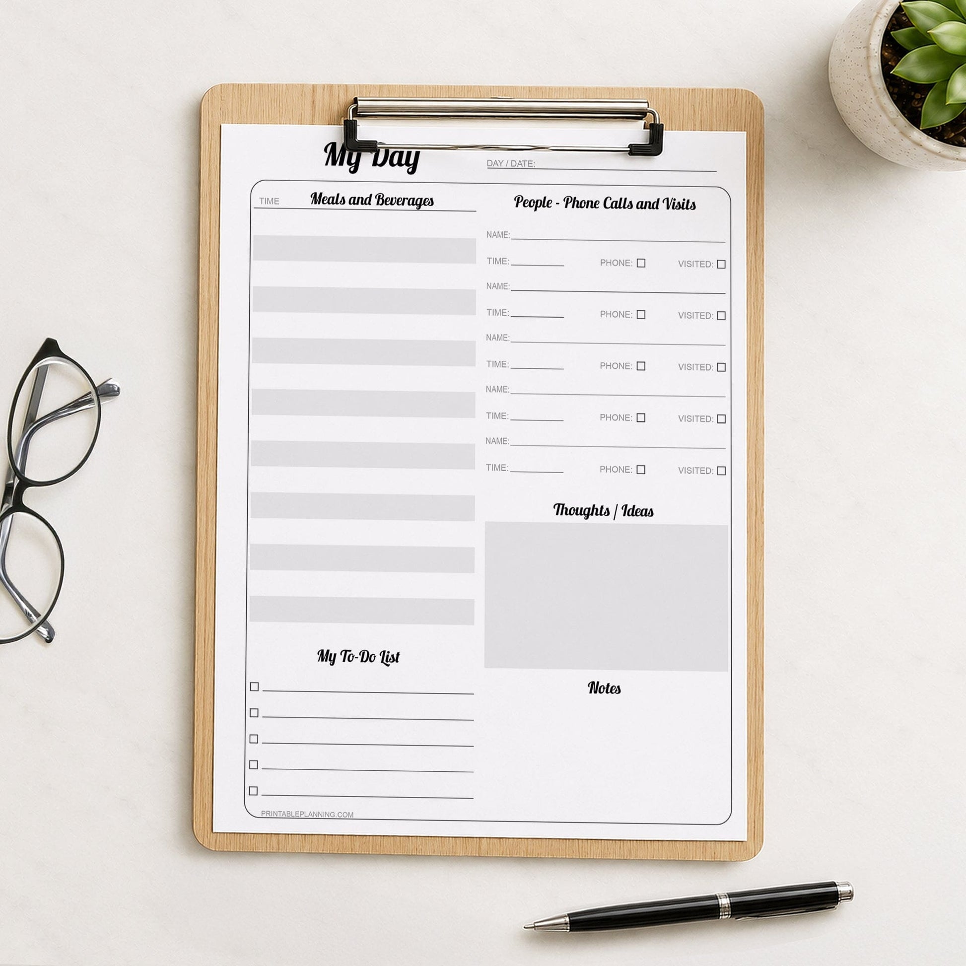 A printed Senior Daily Log for Independent Living and Memory Support (printable page) shown on a wooden clipboard on a table with glasses, a plant, and a pen.