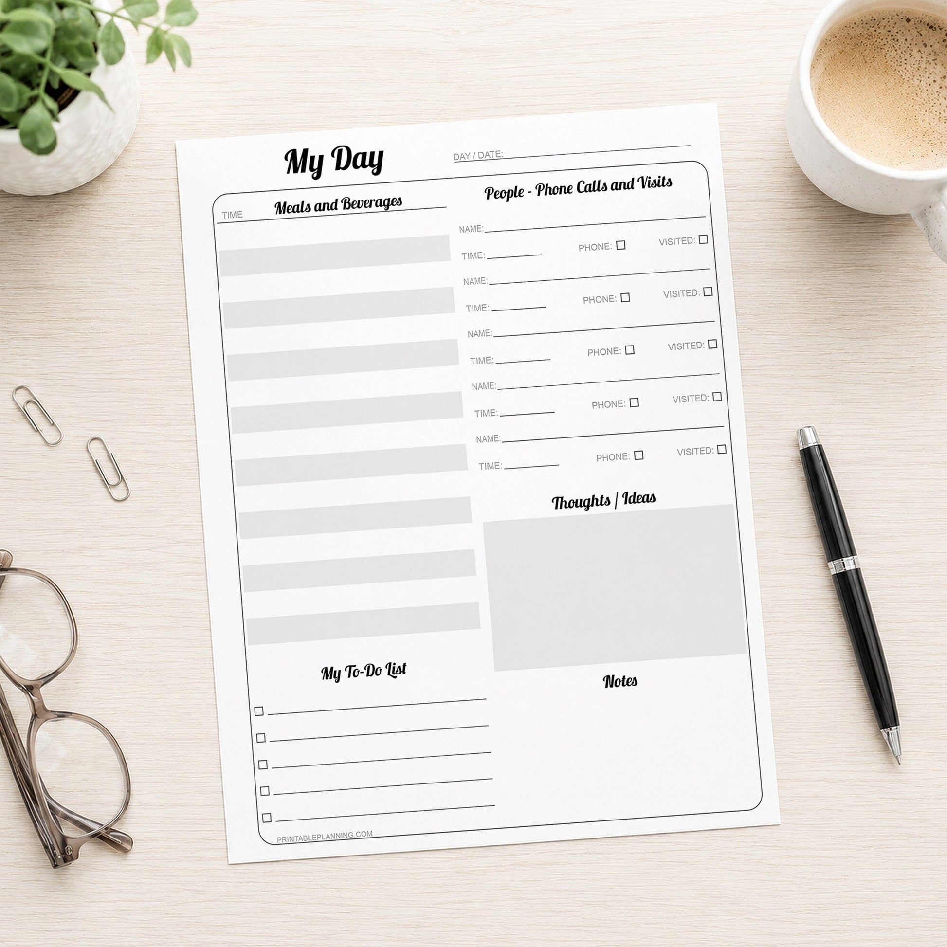 A printed Senior Daily Log for Independent Living and Memory Support (printable page) shown n a light wood table with a plant, glasses, paperclips, coffee, and a pen.