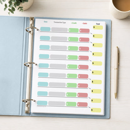 Simple Color-Coded Financial Transaction Register (printable page) shown in a light blue binder with a beverage, plant, and a pen.