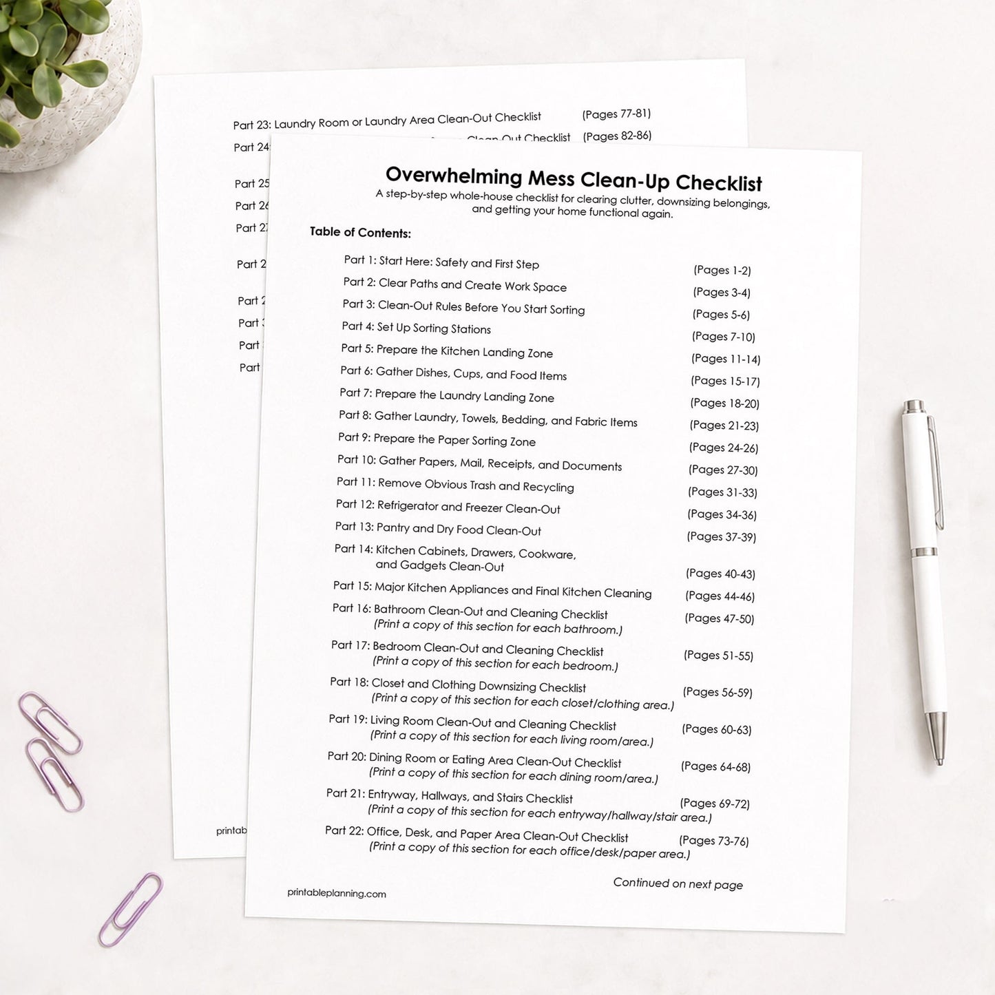 Printed pages of the Table of Contents for the Overwhelming Mess Clean-Up Checklist, shown on a light table with a plant, paperclips, and a pen.