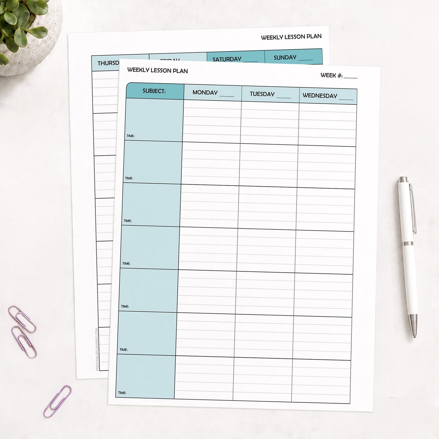 Printed front and back Turquoise Weekly Lesson Plan Pages for Teachers pages shown on a table with a plant, paperclips, and a pen.