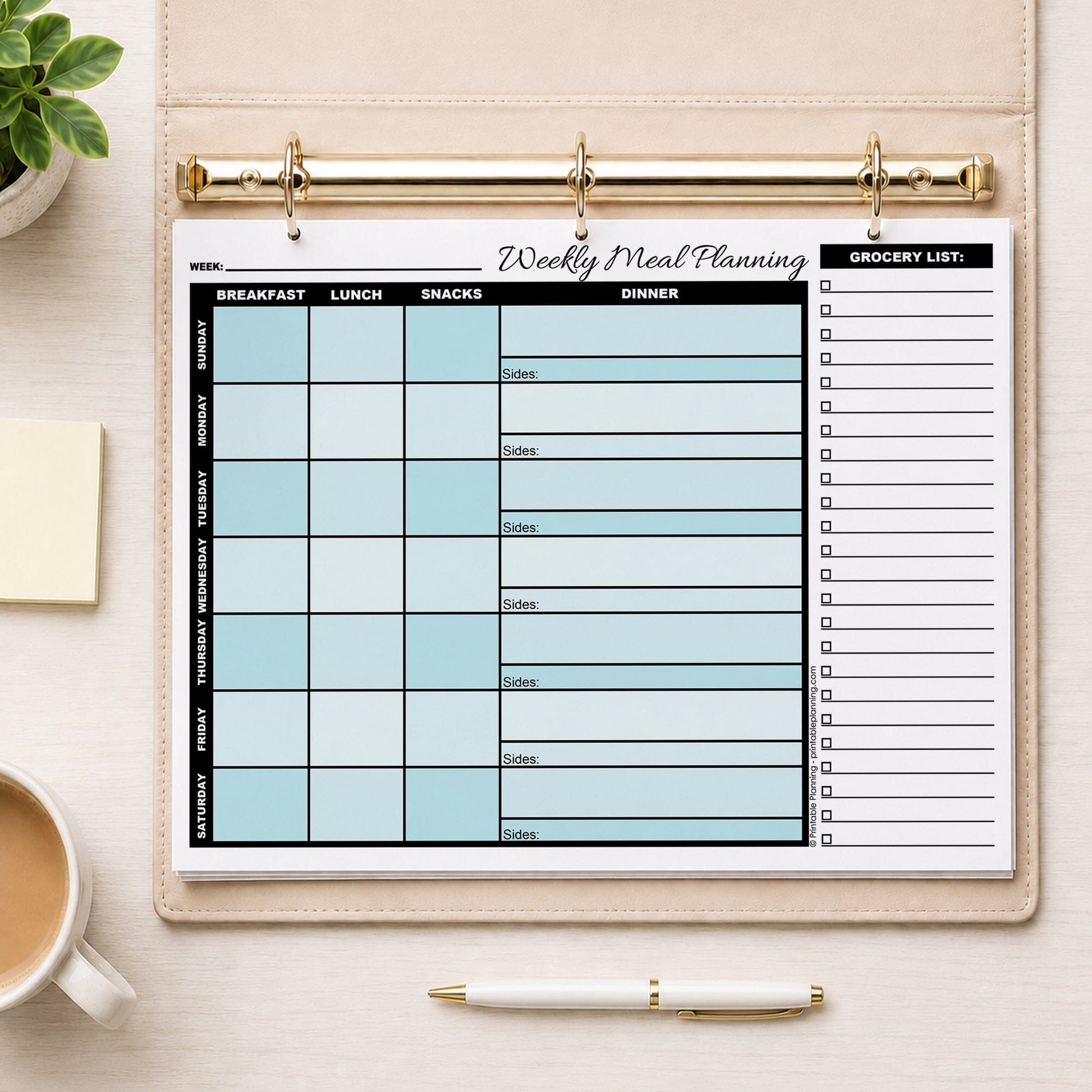 A printed Turquoise Weekly Meal Planner with Grocery List (printable page) shown in a beige binder on a table with a plant, sticky notes, coffee, and a pen.