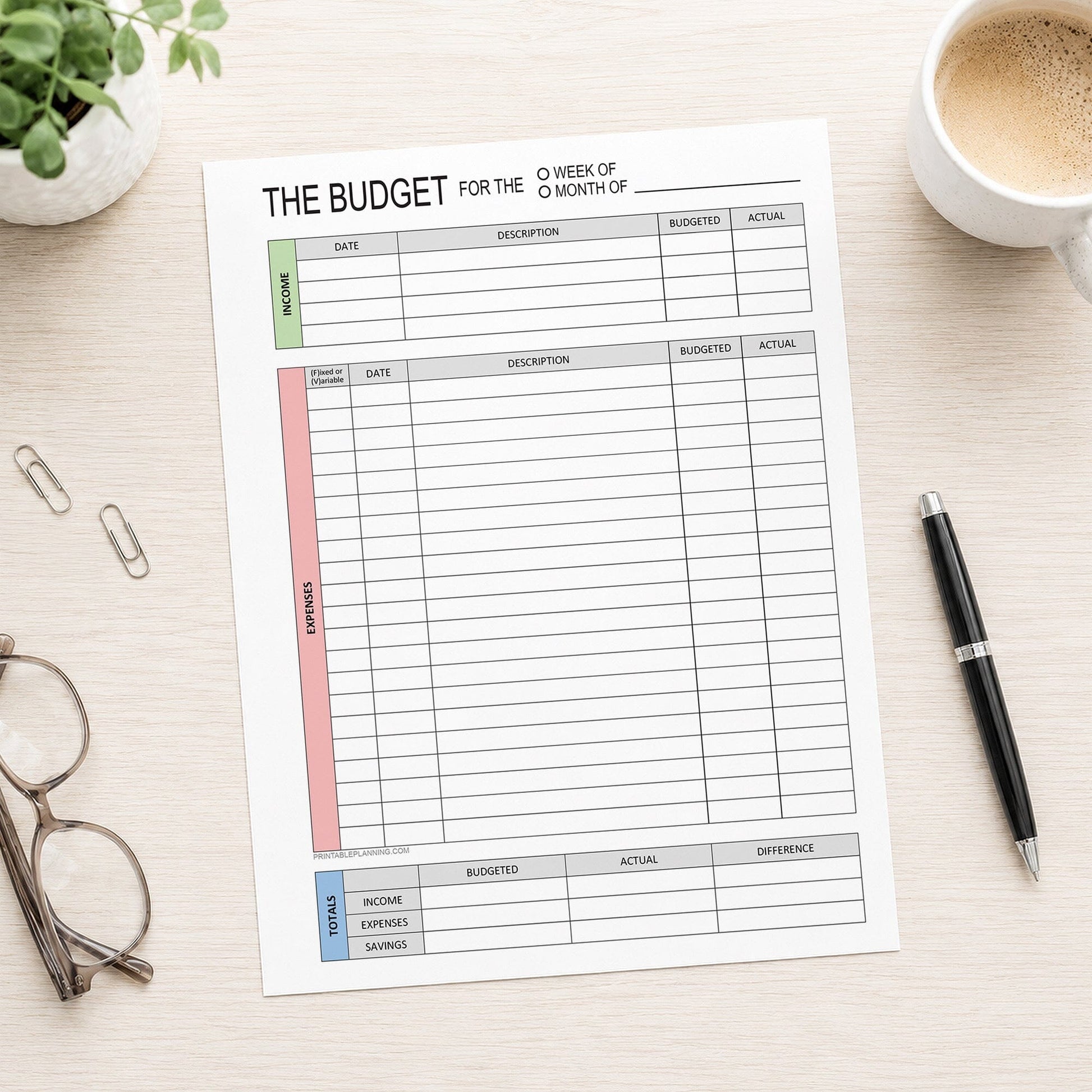A printed page of the Weekly or Monthly Budget Worksheet - Printable Income and Expense Tracker shown on a desk with a plant, glasses, paperclips, coffee, and a pen.