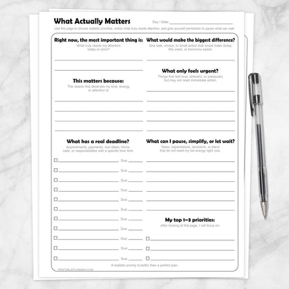 What Actually Matters Priority Worksheet shown on a marble surface with a pen.