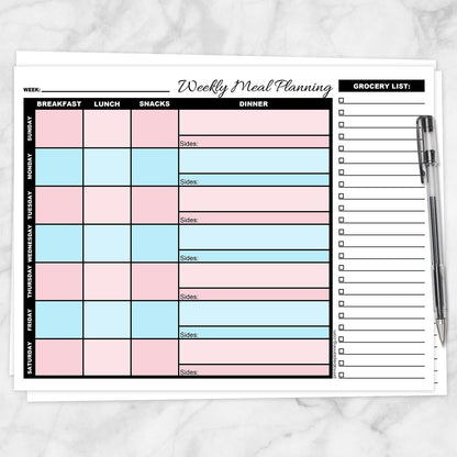 A printable Pink Blue Weekly Meal Planner with Grocery List shown on a marble surface with a pen.