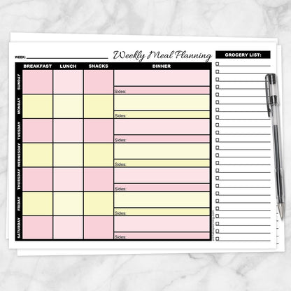 Pink Yellow Weekly Meal Planner with Grocery List shown on a marble surface with a pen.