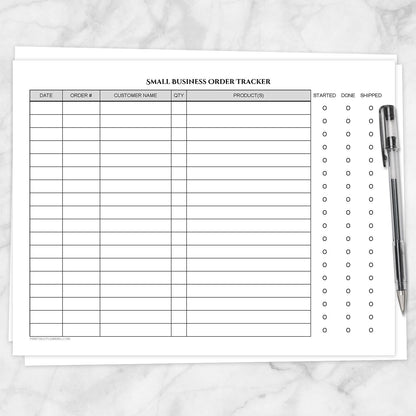 The printable Small Business Order Tracker with Order Status Checklist page shown on a marble surface with a pen.