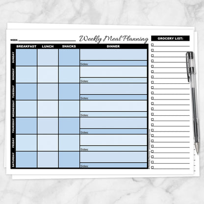 A printable Blue Weekly Meal Planner with Grocery List shown on a marble surface with a pen.