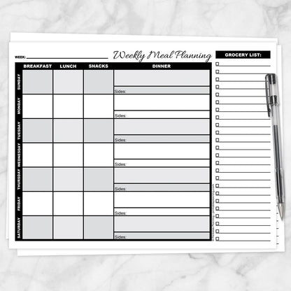 A printable Grayscale Weekly Meal Planner with Grocery List shown on a marble surface with a pen.