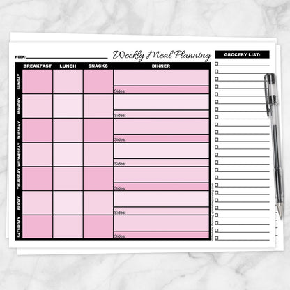 A printable Pink Weekly Meal Planner with Grocery List shown on a marble surface with a pen.